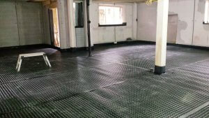 An image showing an interior with a rubber floor where work is being carried out to prevent damp