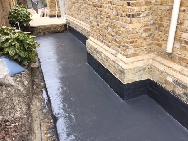 An image showing a garden pavement and wall that has been damp proofed