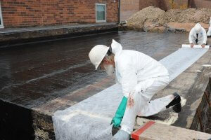 an image of contractors waterproofing the foundations of a building